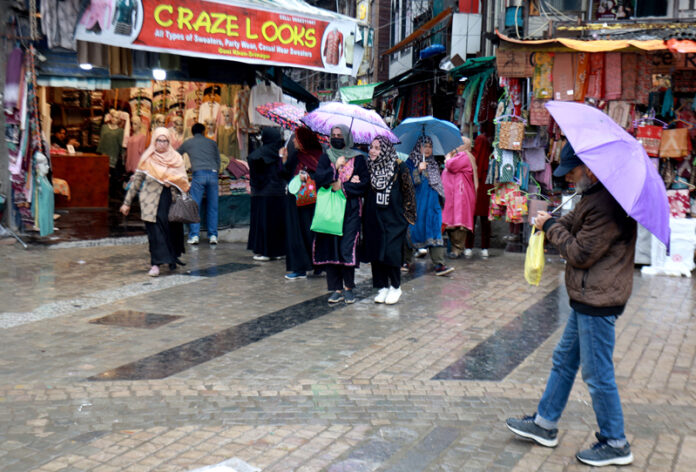 Shoppers move with umbrellas through a rain-soaked market in Srinagar city on Wednesday. -Excelsior/Shakeel Shoppers move with umbrellas through a rain-soaked market in Srinagar city on Wednesday. -Excelsior/Shakeel