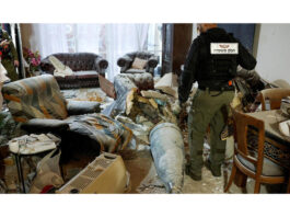 A member of the Israeli Police inspects part of an Iranian missile in a living room, after Tehran launches barrage of missiles towards Israel on Friday.