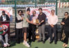 Winner receiving memento from dignitaries during prize distribution ceremony.