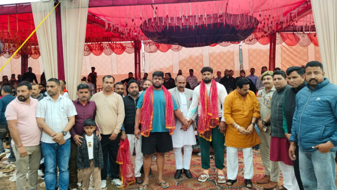 Wrestlers posing along with dignitaries during programme.