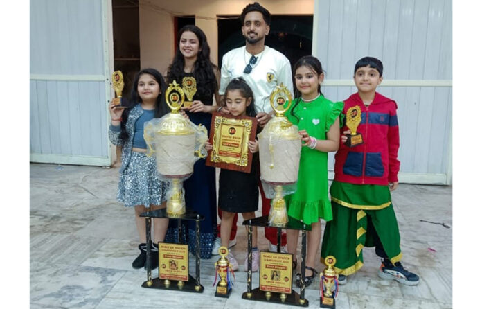 Students of Street Dance Hub posing with trophies.