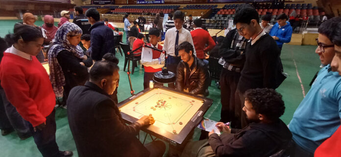 Carrom players in action during a match.