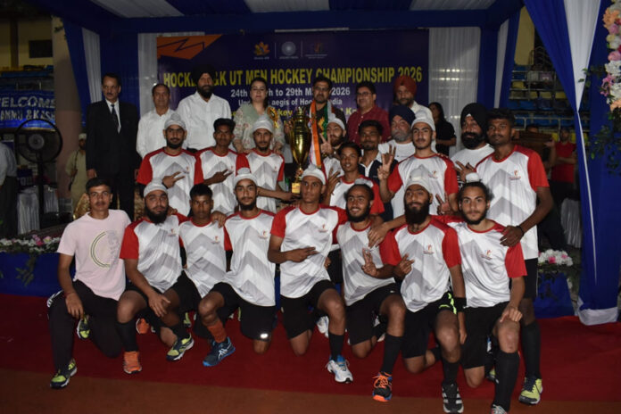 Winning team posing along with trophy and dignitaries.