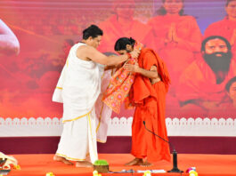 Acharya Bal Krishan puts shawl over Swami Ramdev during a function to celebrate 32nd Sanyas Diwas of Swami Ramdev in Haridwar.