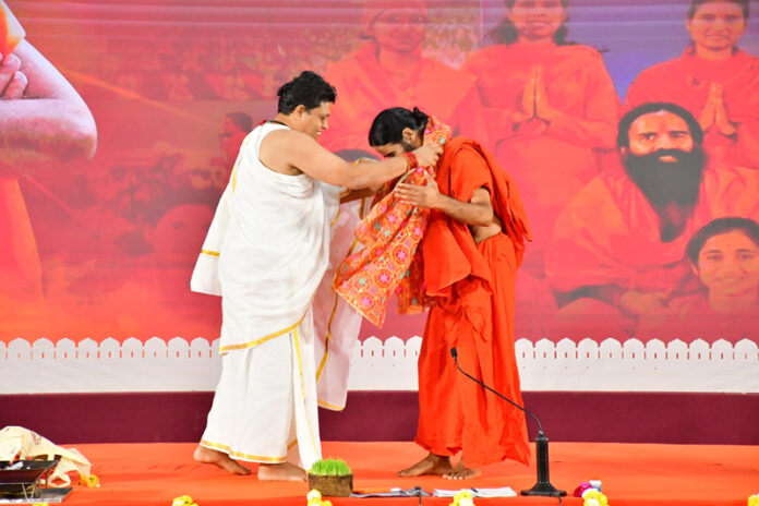Acharya Bal Krishan puts shawl over Swami Ramdev during a function to celebrate 32nd Sanyas Diwas of Swami Ramdev in Haridwar. Acharya Bal Krishan puts shawl over Swami Ramdev during a function to celebrate 32nd Sanyas Diwas of Swami Ramdev in Haridwar.