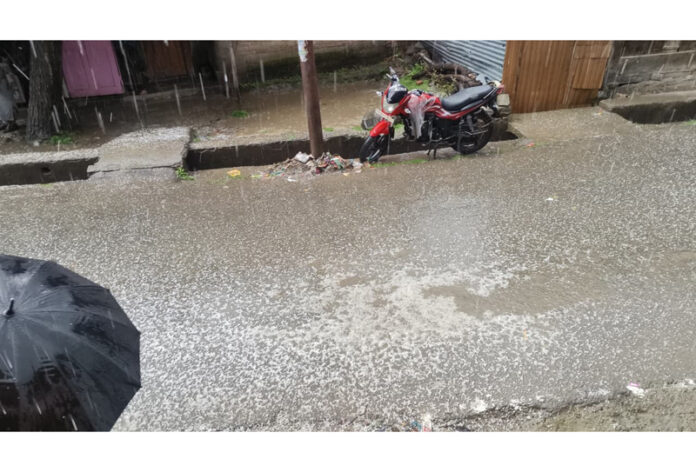 A view of hailstrom at Kund, Kulgam on Monday. -Excelsior/Sajad Dar