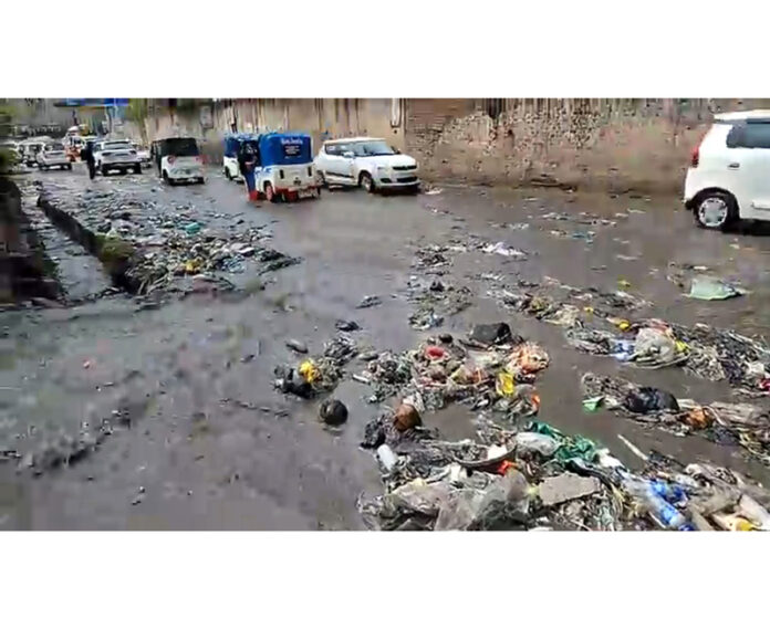 Garbage spread all over the road after drains blockade near District Police Lines in Rajouri on Monday. -Excelsior/Imran