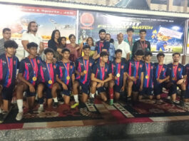 Winning team posing along with trophy and medals during prize distribution ceremony.