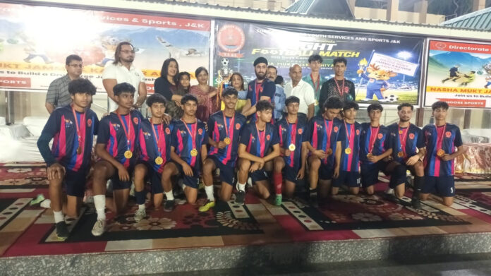 Winning team posing along with trophy and medals during prize distribution ceremony.