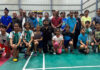 Dignitaries posing along with young shuttlers during a programme.