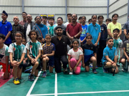Dignitaries posing along with young shuttlers during a programme.