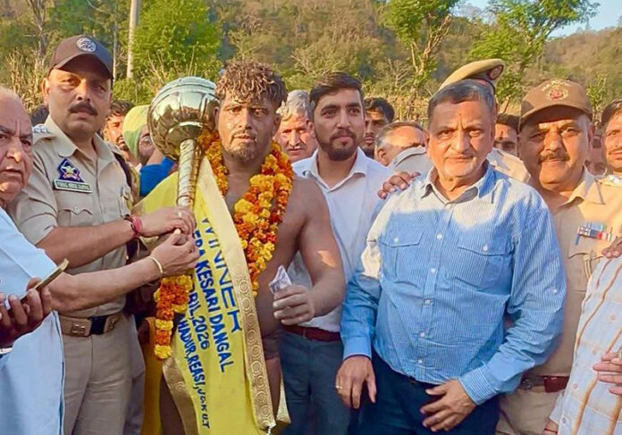 Wrestler posing along with dignitaries after winning the title.