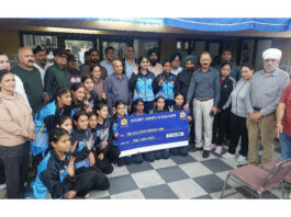 Sub-Junior Women's Hockey team posing along with cheque alongside dignitaries.