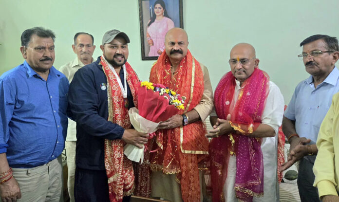 MLA Jammu East Yudhvir Sethi felicitating young handball player Anuj Langer.
