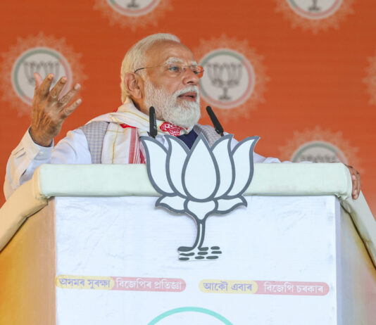 Prime Minister Narendra Modi addresses the public meeting in Barpeta, Assam on Monday. (UNI)