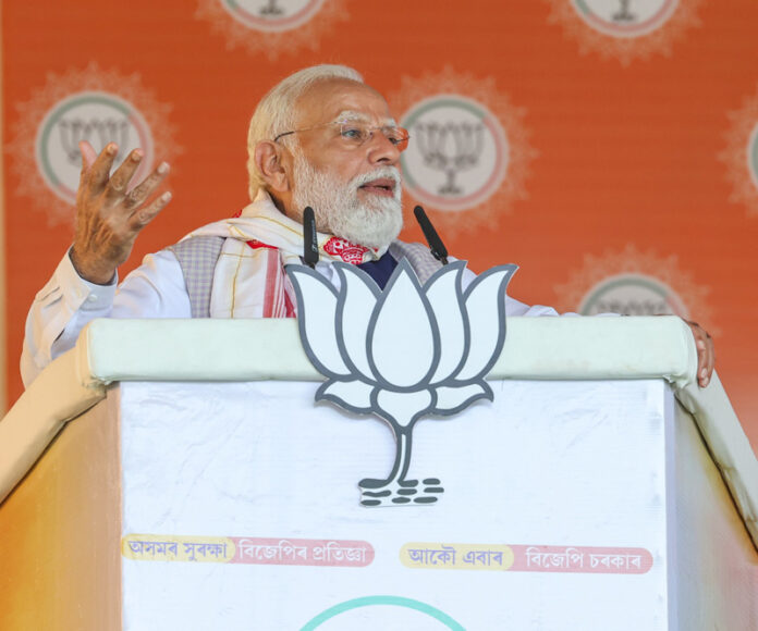 Prime Minister Narendra Modi addresses the public meeting in Barpeta, Assam on Monday. (UNI)