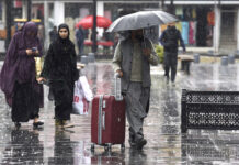 People walk with their umbrellas during rainfall in Srinagar on Friday. — Excelsior/Shakeel
