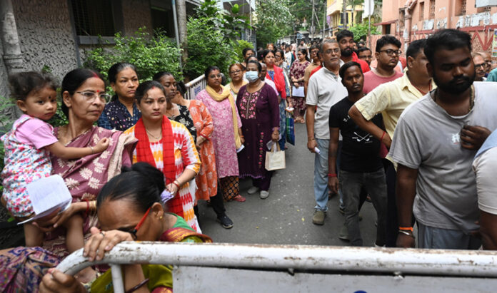 People wait in long queues to cast their votes during the West Bengal Assembly polls at the Belgachhia constituency in Kolkata on Wednesday. (UNI)
