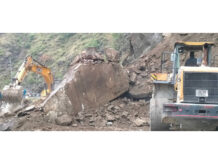 Two machines clearing boulders from Jammu-Srinagar National Highway near Digdole in Ramban on Tuesday. -Excelsior/Parvaiz Mir