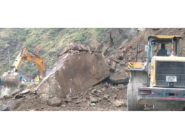 Two machines clearing boulders from Jammu-Srinagar National Highway near Digdole in Ramban on Tuesday. -Excelsior/Parvaiz Mir