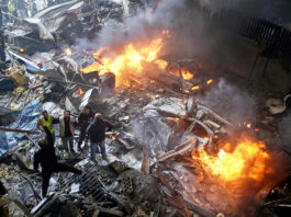 First responders and volunteers search through the rubble and burning cars at the site of an Israeli airstrike in Beirut, Lebanon on Wednesday.