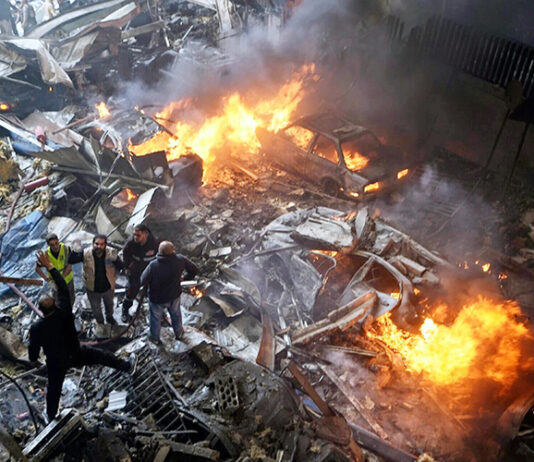 First responders and volunteers search through the rubble and burning cars at the site of an Israeli airstrike in Beirut, Lebanon on Wednesday.