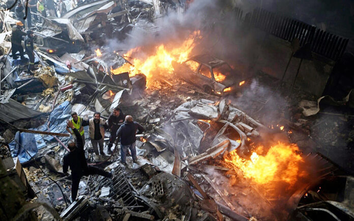 First responders and volunteers search through the rubble and burning cars at the site of an Israeli airstrike in Beirut, Lebanon on Wednesday.