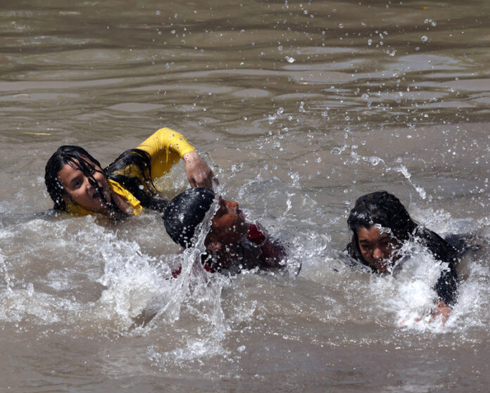 People enjoying bath in Ranbir canal on a hot summer day in Jammu. - Excelsior/Rakesh