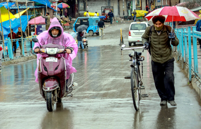 People walk with their umbrellas during rainfall in Srinagar on Wednesday. -Excelsior/Shakeel
