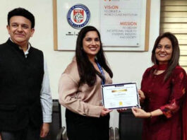 Dignitary receiving memento from management during a programme.