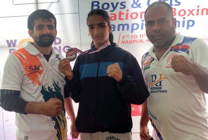 Udhampur Boxer Neelam Devi posing with her coach Rajneesh Kumar after winning bronze in Junior National Boxing Championship, in Nagpur.