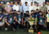 Dignitaries posing along with trophy during closing ceremony.