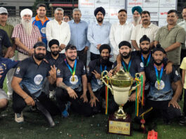 Dignitaries posing along with trophy during closing ceremony.