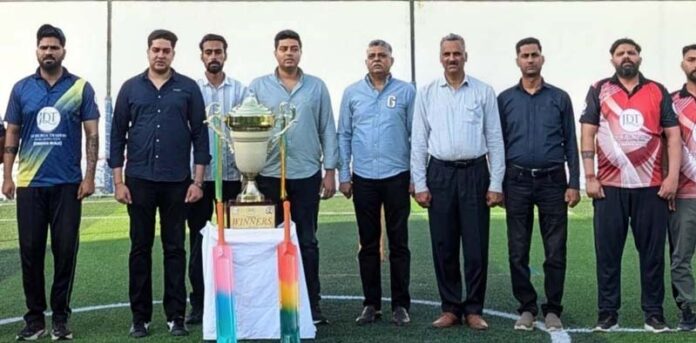 Organizing team of Mega Box Cricket Tournament posing with title trophy.