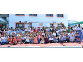 Students with certificates posing along with dignitaries during a programme.