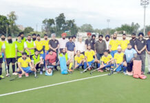 Hockey players posing along with dignitaries.
