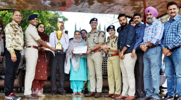 Dignitaries presenting trophy and certificates during a programme.