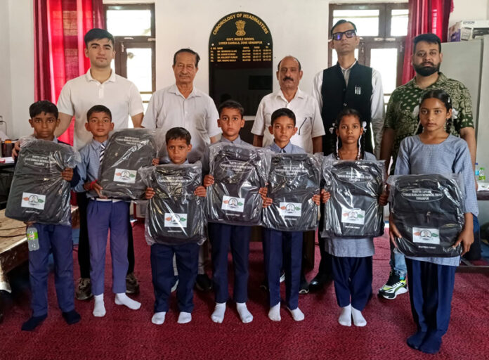 Dignitaries posing with students during shoes and bags distribution ceremony.