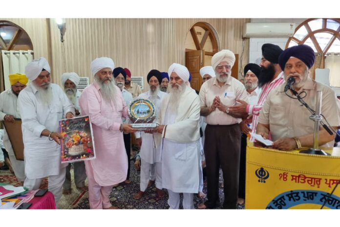 Mahant Manjit Singh being presented a 'Siropa' during a religious programme at Digiana Ashram on Monday.