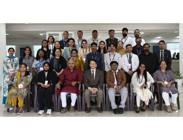 Dignitaries posing along with participants during a programme at IIM Jammu.