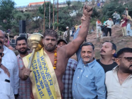 Wrestler posing along with dignitaries.