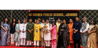 Jodhamal Public School delegation posing with trophy during a programme.