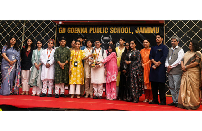 Jodhamal Public School delegation posing with trophy during a programme.