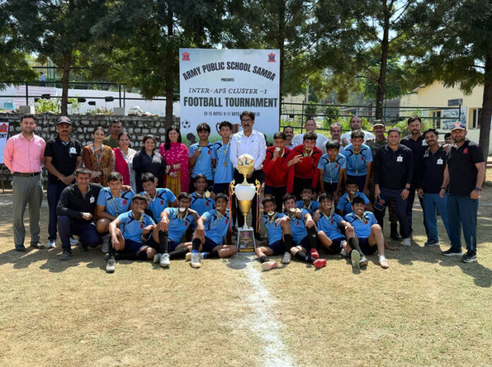 Winning team posing along with trophy alongside dignitaries during a programme.