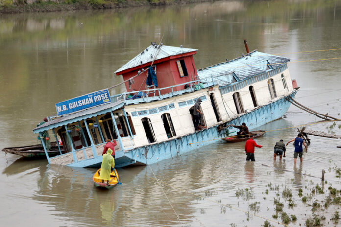 Partially sinked houseboat near Zero Bridge on the Jehlum river in Srinagar on Wednesday. —Excelsior/Shakeel