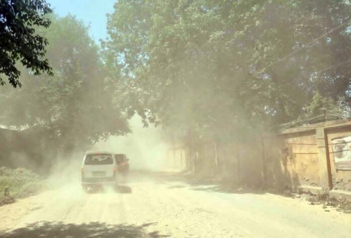 A vehicle moves through dust and high air pollution on a Rajouri road. —Excelsior/ Imran