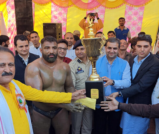 MLA Ramban Arjun Singh Raju presenting trophy to the winner wrestler.