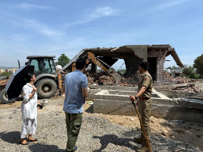 An illegal structure being demolished during an anti-encroachment drive in Jammu district on Monday.