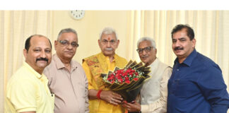 A delegation of Shiv Mandir Charitable Trust posing with LG Manoj Sinha.
