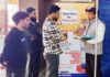 Railway staff helping passengers to download and install ‘RailOne’ app on their mobile phones during awareness campaign.